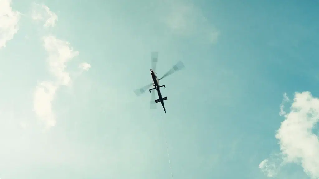 Une photographie d'un hélicoptère transportant des bobines de câbles pour Nexans